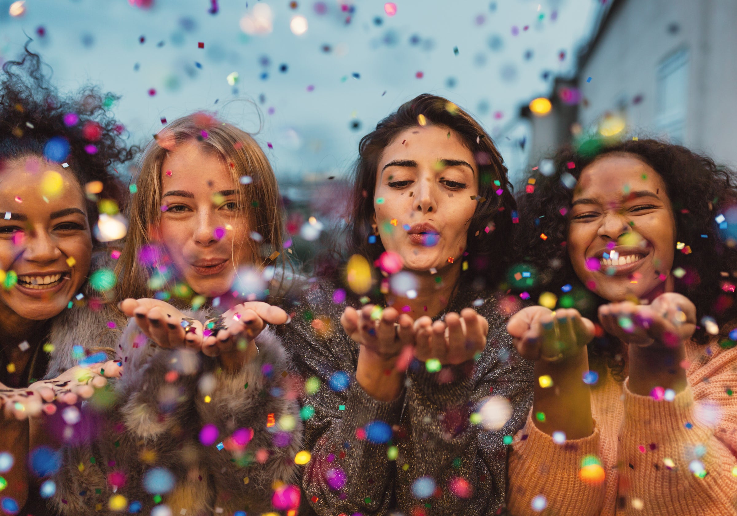 4 girls blowing confetti